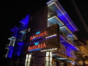 a building with a sign that reads imperial imperia at night at Imperia President in Paralia Katerinis