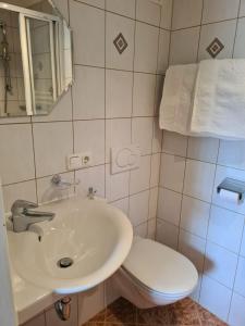uma casa de banho com um lavatório branco e um WC. em Apartment Familie Webhofer em Kartitsch