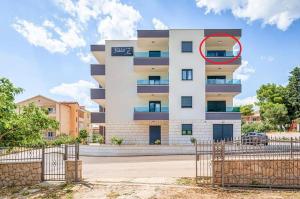 a building with a red circle on the side of it at Villa Ivo Apartmani in Promajna