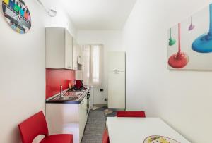 アヴォラにあるVilla Teocrito, Piscina & Mareのキッチン(白いキャビネット、赤い椅子、テーブル付)