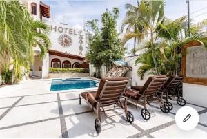 a house with two chairs and a swimming pool at HOTEL VILLAS XAIBA in Puerto Escondido