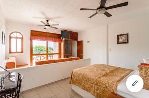 a bedroom with a bed and a living room at HOTEL VILLAS XAIBA in Puerto Escondido