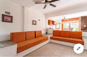 a living room with an orange couch in a room at HOTEL VILLAS XAIBA in Puerto Escondido
