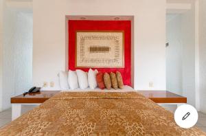 a bedroom with a bed with a red head board at HOTEL VILLAS XAIBA in Puerto Escondido