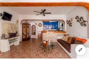 a living room with a couch and a ceiling fan at HOTEL VILLAS XAIBA in Puerto Escondido