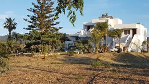 a large white building with trees in front of it at Eftihia Apartments in Kos
