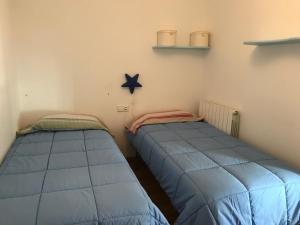 Dos camas azules en una habitación con una estrella en la pared en Apartamento Pajaro Loco, en Castejón de Sos