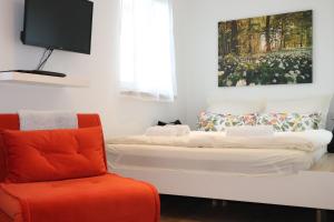 ein Wohnzimmer mit 2 Betten und einem Stuhl in der Unterkunft Casa Stetten in Lörrach