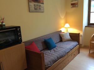 - un canapé avec des oreillers dans le salon dans l'établissement Résidence Grand Hôtel, à Aulus-les-Bains