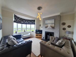 a living room with two couches and a fireplace at Sea Dunes - Fantastic North Sea Views on your door step. in Whitley Bay