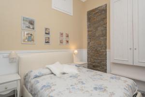 een slaapkamer met een bed en een stenen muur bij Casamia in Agropoli