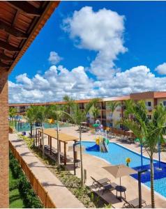 ポルト・セグロにあるOndas Praia Resortのヤシの木とテーブルのあるプールを併設しています。