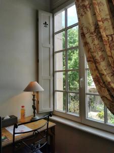 a room with a desk and a window at Hotel Des Prélats in Nancy