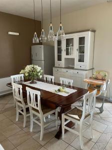 a kitchen with a wooden table and white chairs at Villa Mancosta in Marinella di Selinunte