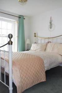 a bedroom with a white bed with a canopy at Higher Primrose Cottage in Winkleigh