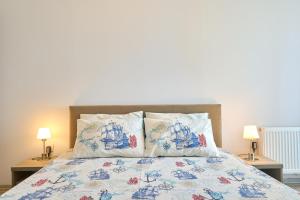 a bed with two pillows on it with two lamps at Alina Lake View Apartment in Mamaia