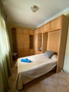 a small bedroom with a bed and wooden cabinets at Apartamento centrico castillo s. Barbara in Alicante