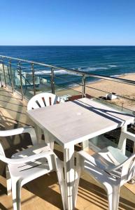 a white table and chairs on a balcony with the ocean at BEACH APARTMENT no 17 in St. St. Constantine and Helena