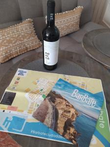 een fles wijn op een tafel naast een tijdschrift bij La Motilla in Barbate