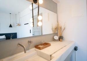 uma casa de banho com um lavatório e um espelho em Magoo Suites em Logaras