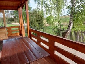 a wooden porch with a view of a tree at Domki pod Brzozą in Czarnocin +21 photos