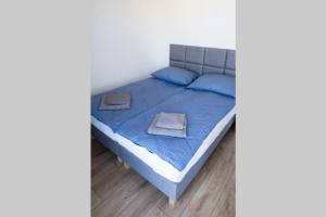 a bedroom with a blue bed with blue sheets and blue pillows at Apartament BlueBay in Puck