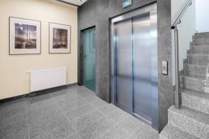 an elevator lobby with a glass door and stairs at Apartament BlueBay in Puck