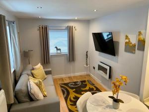 a living room with a couch and a table at Detached one bedroom house near to castle and cathedral in Lincoln