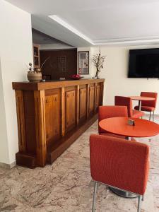 poczekalnia ze stołem, krzesłami i telewizorem w obiekcie Nafplia Hotel w Nauplionie