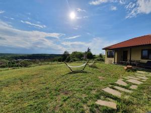 a chair sitting in a field next to a house at Malavi Guest House Krasen! Comfort&clean! in Krasen