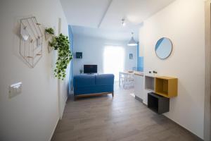 a living room with a blue couch and a table at GLBapartments in Capo dʼOrlando