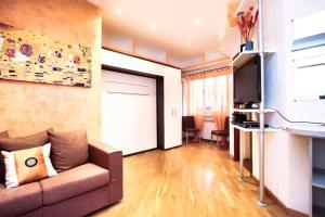 a living room with a couch and a television at PETITE HOME IN ROME in Rome