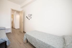 a white bedroom with a bed and aorc at GLBapartments in Capo dʼOrlando +41 photos