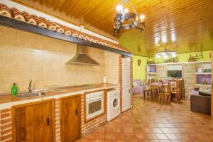 a kitchen with a sink and a stove top oven at Don Mauricio y periquines in Robledillo