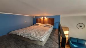 1 dormitorio con cama y pared azul en Apartament Parkowy Antresola en Gniezno
