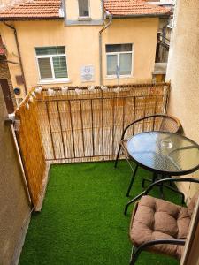 a balcony with a table and chairs and a fence at Malavi DV2 top center apartment Ruse in Ruse