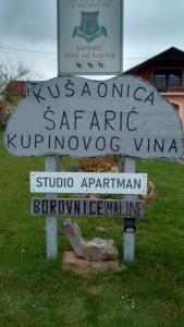 a sign in the grass with a sign for a winehement at Studio apartman Šafarić in Sveti Martin na Muri