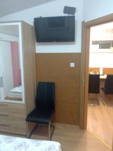 Zimmer mit einem Stuhl und einem TV an der Wand in der Unterkunft Studio apartman Šafarić in Sveti Martin na Muri