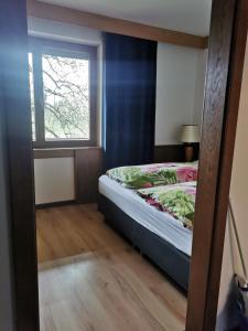 a small bedroom with a bed with a window at Erlebnishof Tschabitscher in Weissensee