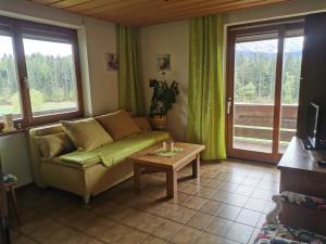 a living room with a couch and a table at Erlebnishof Tschabitscher in Weissensee