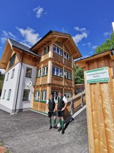 Dwóch mężczyzn stoi przed budynkiem. w obiekcie Ferienwohnungen Kalss nahe Altaussee w mieście Bad Aussee