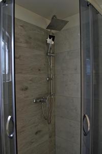 a shower with a shower head in a bathroom at Domek nad jeziorem, a morze w gratisie in Wisełka