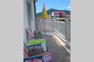 a balcony with chairs and a table and a sailboat at Apartman Budva Ivana in Budva