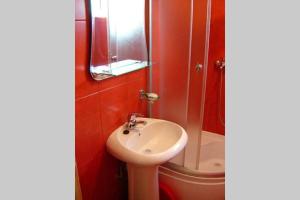 a bathroom with a white sink and a shower at Apartman Budva Ivana in Budva