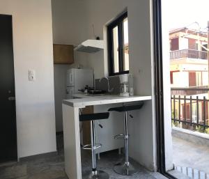 a kitchen with a counter and two bar stools at Amalthia Hotel Apartments in Rethymno +58 photos