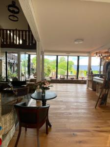 a living room with tables and chairs and windows at Manoir De Rigourdaine in Plouër-sur-Rance