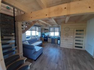 a living room with a couch and a kitchen at Domek u Andrzeja 2 in Ciche
