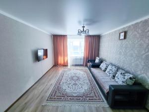 uma sala de estar com um sofá e um tapete em Элитные апартаменты в Центре em Semei