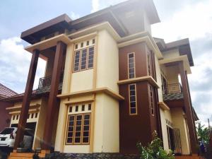 a large house with a car parked in front of it at House of Runsia Guesthouse in Pagaralam