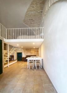 una sala da pranzo con tavolo e soppalco di Casa Flavia a Ostuni